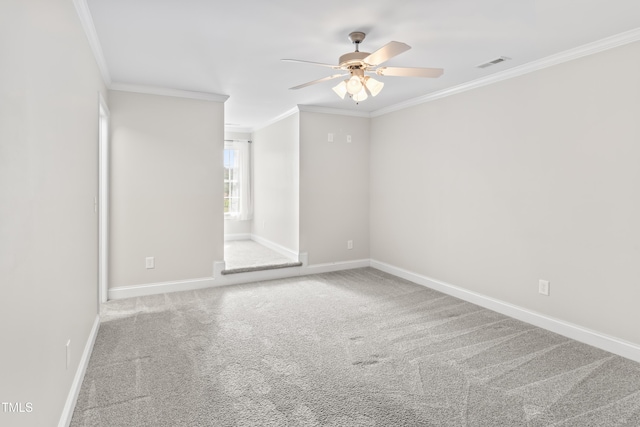 carpeted empty room featuring a ceiling fan, baseboards, visible vents, and crown molding