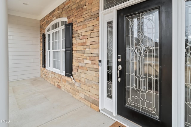 property entrance featuring covered porch and brick siding