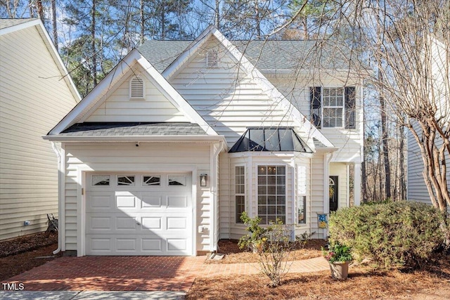 view of front of property with a garage, decorative driveway, and roof with shingles