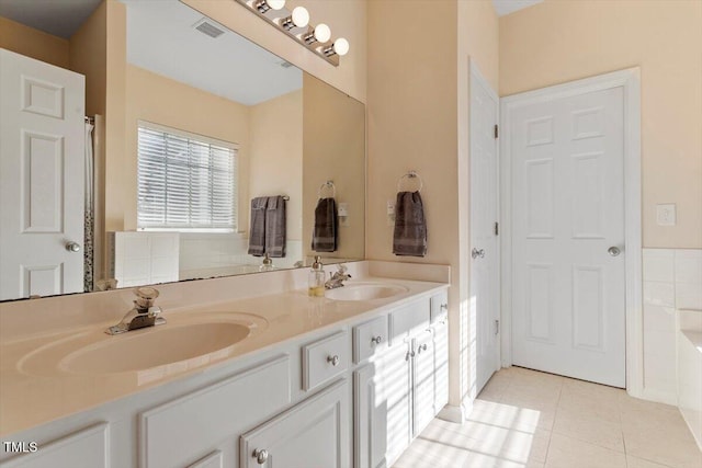 full bath featuring double vanity, visible vents, a sink, and tile patterned floors