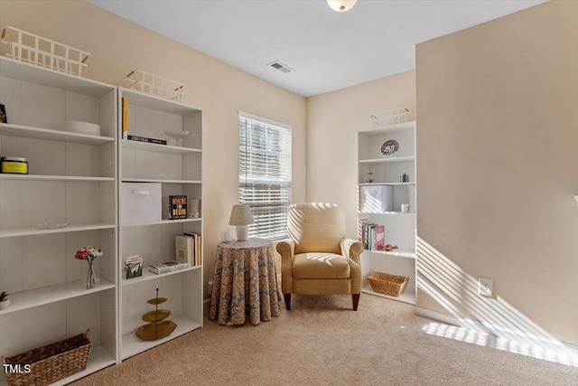 living area featuring carpet floors, visible vents, and built in features