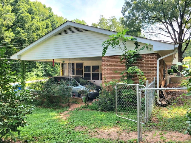 view of front of house with a carport, a gate, brick siding, and fence