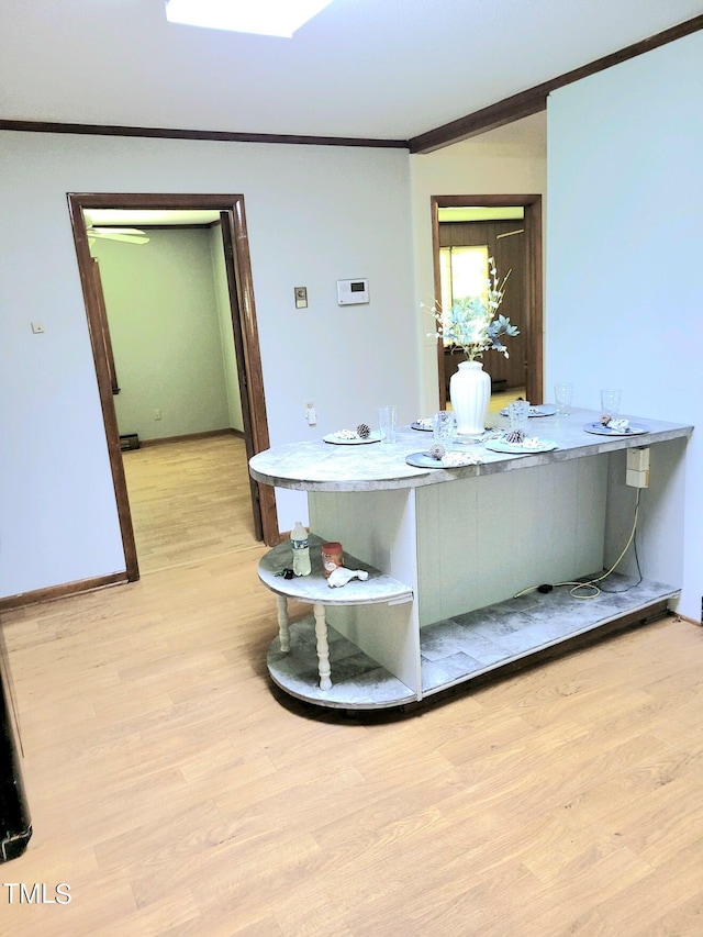 bathroom with baseboards, crown molding, and wood finished floors