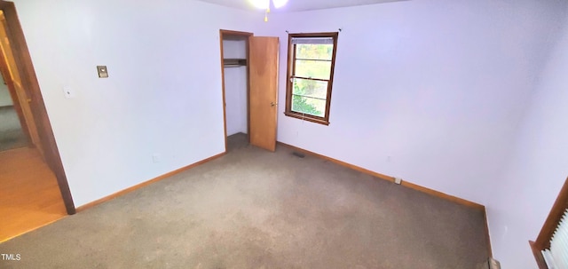 carpeted spare room featuring baseboards