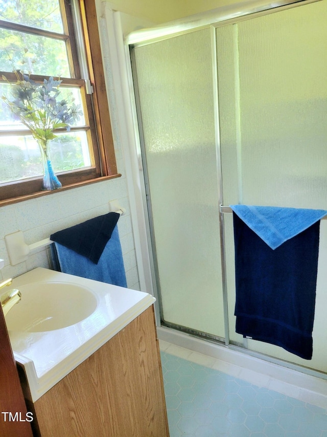 bathroom with a shower stall and vanity