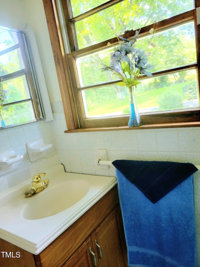 bathroom with tile walls, vanity, and decorative backsplash