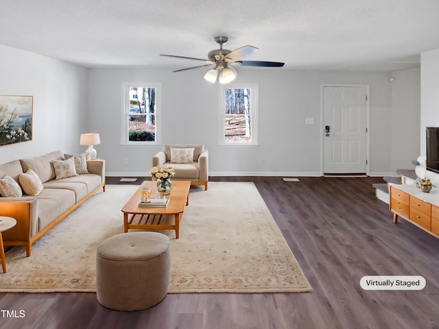 living room featuring a ceiling fan, baseboards, and wood finished floors