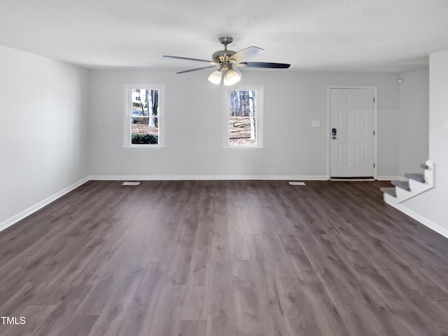 interior space with dark wood-type flooring, stairway, baseboards, and a ceiling fan