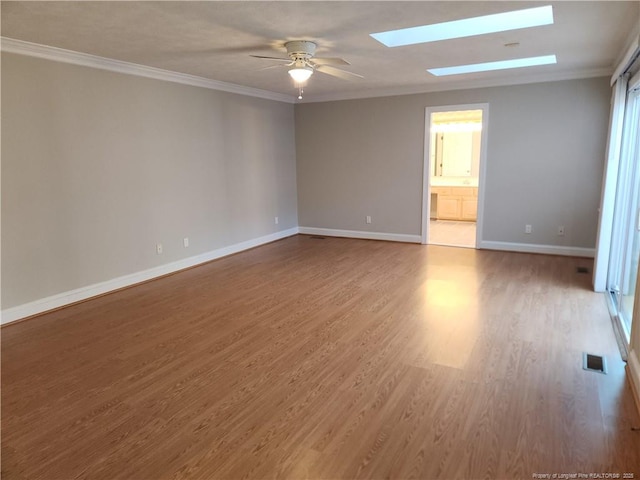 2814 Millbrook Rd, Fayetteville, NC 28303 - spare room with a skylight, crown molding, visible vents, wood finished floors, and baseboards