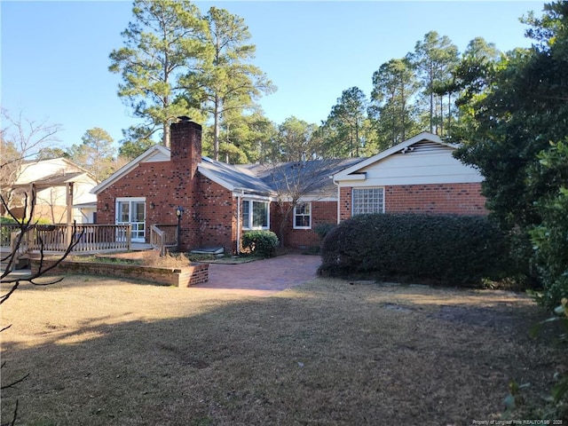 2814 Millbrook Rd, Fayetteville, NC 28303 - back of house featuring a deck, brick siding, and a chimney