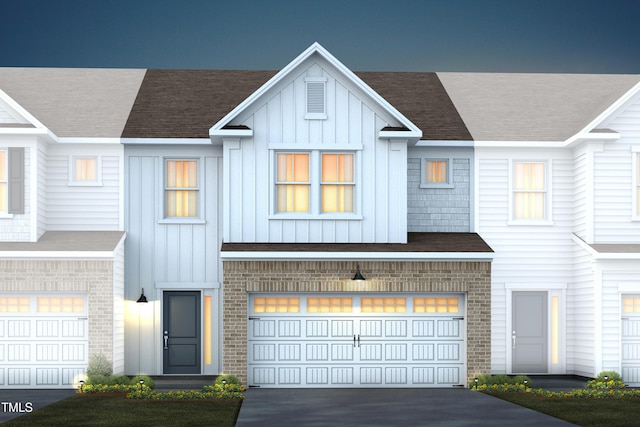 view of property with driveway, a garage, board and batten siding, and brick siding