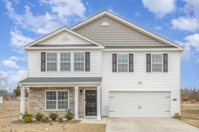 traditional-style home featuring stone siding, an attached garage, and driveway