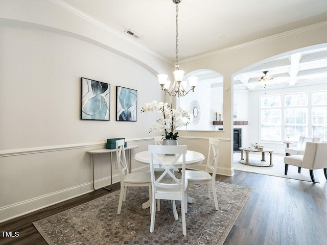 dining room with coffered ceiling, a glass covered fireplace, visible vents, and dark wood finished floors