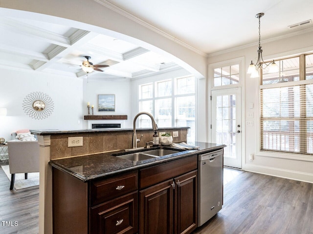 kitchen with wood finished floors, stainless steel dishwasher, a sink, and crown molding