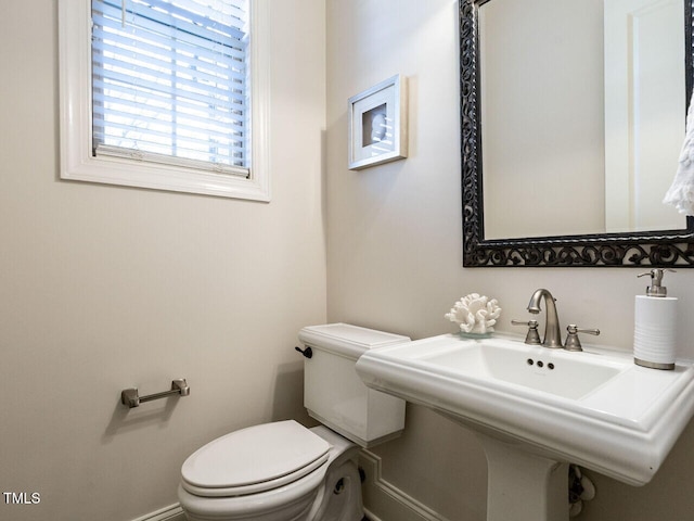 half bathroom with toilet and a sink