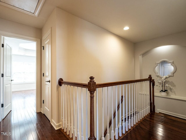 hall featuring dark wood-style flooring, an upstairs landing, and recessed lighting