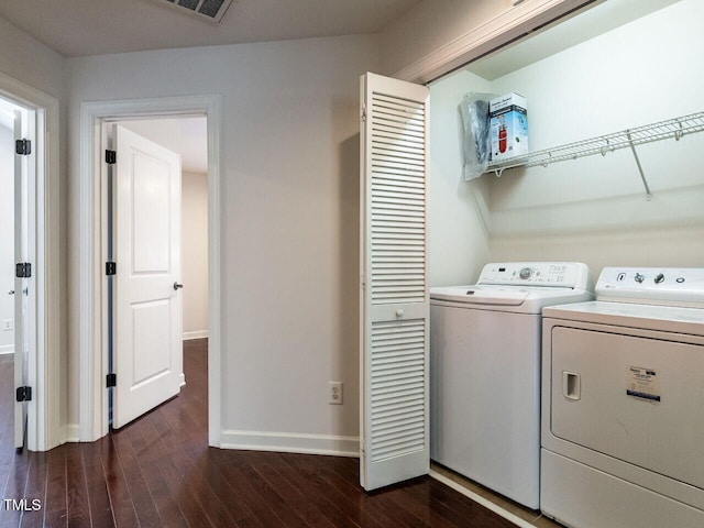 laundry area featuring dark wood-type flooring, laundry area, baseboards, and separate washer and dryer