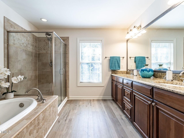 full bathroom with a wealth of natural light, a sink, a shower stall, and double vanity