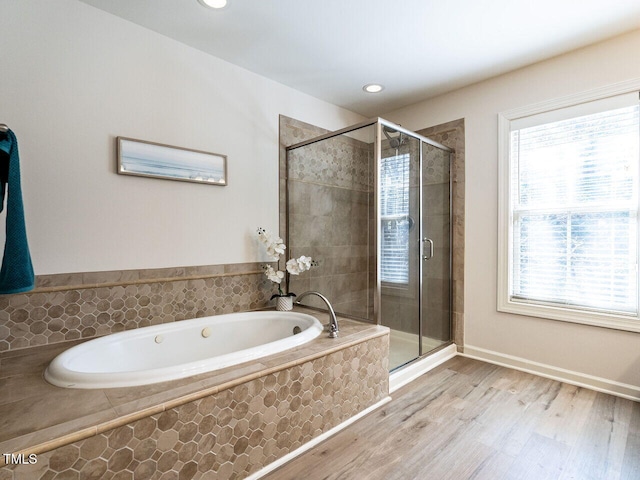 bathroom featuring a garden tub, a shower stall, wood finished floors, and recessed lighting