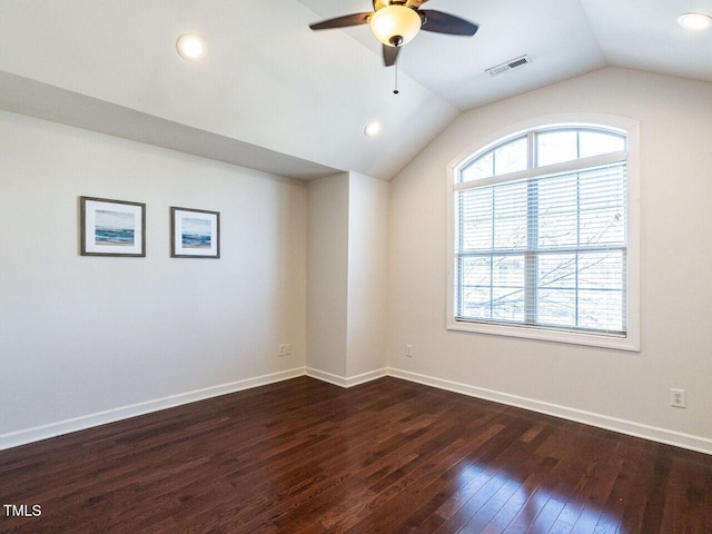 unfurnished room featuring a healthy amount of sunlight, visible vents, vaulted ceiling, and dark wood-type flooring