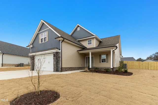 view of front of property featuring roof with shingles, central air condition unit, an attached garage, fence, and driveway