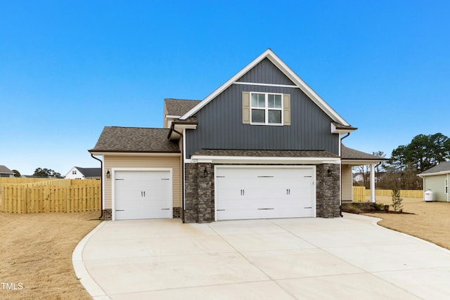 view of front of home with an attached garage, a shingled roof, fence, and concrete driveway