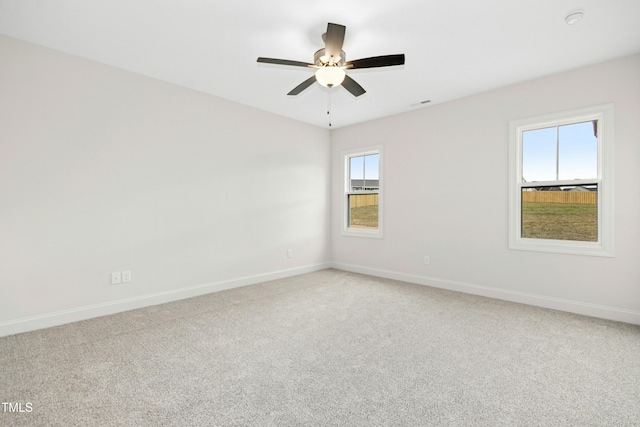 empty room featuring ceiling fan, baseboards, and light colored carpet