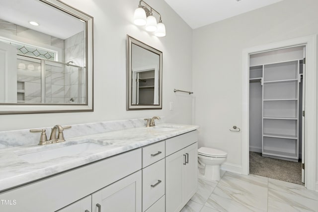 full bath with a walk in closet, marble finish floor, a sink, and a shower stall