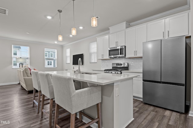 kitchen featuring tasteful backsplash, appliances with stainless steel finishes, a sink, and crown molding