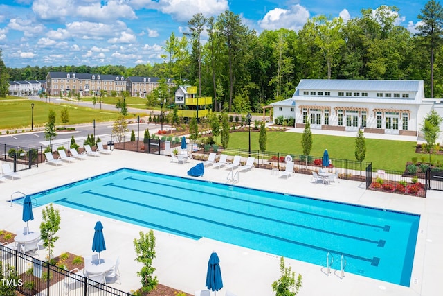 pool featuring fence, a lawn, and a patio