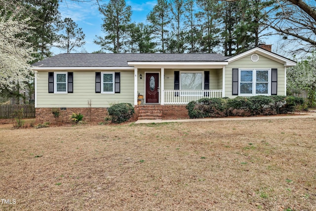 ranch-style home with fence, roof with shingles, covered porch, a chimney, and a front lawn