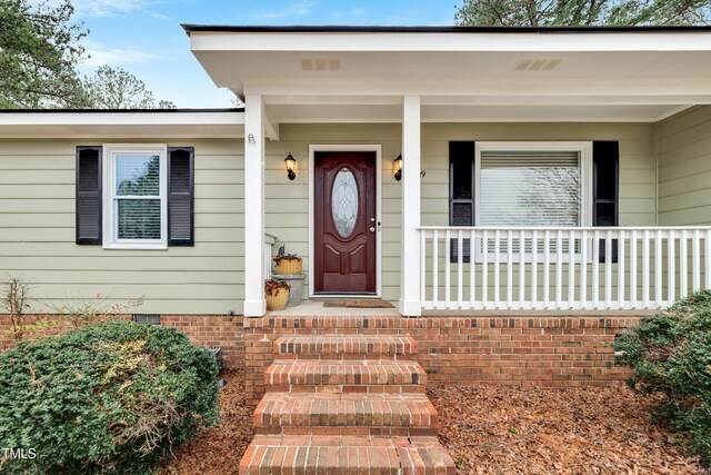 doorway to property featuring crawl space and a porch