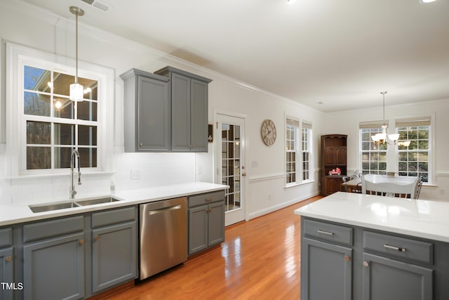 kitchen with a sink, a chandelier, dishwasher, and gray cabinetry