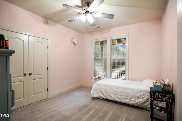 carpeted bedroom featuring baseboards, a closet, visible vents, and a ceiling fan