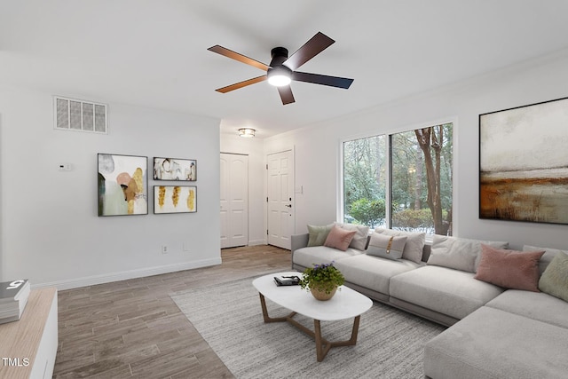 living room with ceiling fan, wood finished floors, visible vents, and baseboards