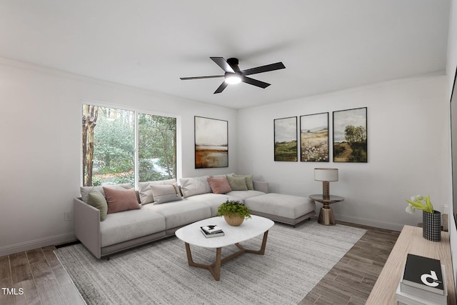 living room featuring a ceiling fan, wood finished floors, and baseboards