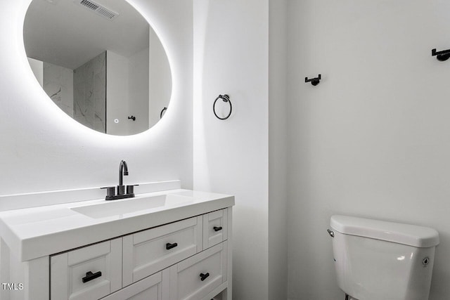 bathroom featuring visible vents, toilet, and vanity