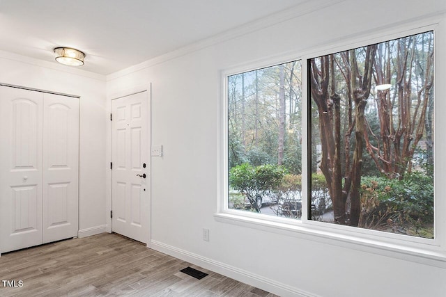 foyer entrance with a healthy amount of sunlight, visible vents, and ornamental molding