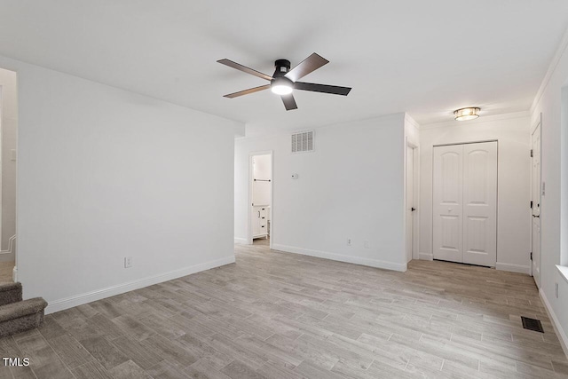 unfurnished living room featuring visible vents, baseboards, stairs, and light wood finished floors