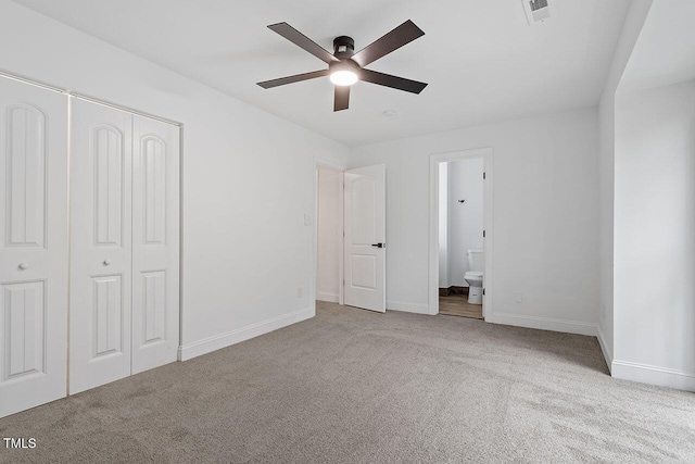 unfurnished bedroom with baseboards, visible vents, carpet floors, ensuite bath, and a closet