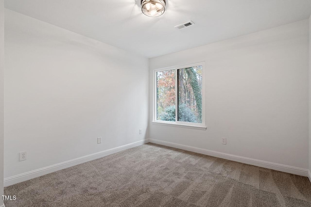 spare room featuring carpet flooring, baseboards, and visible vents