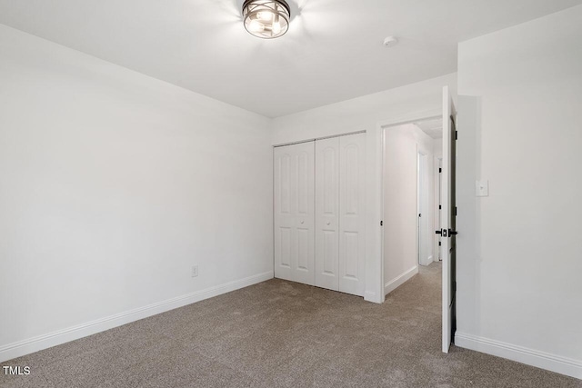 unfurnished bedroom featuring a closet, baseboards, and carpet