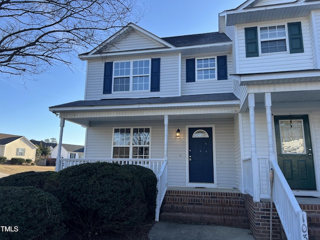 view of front of property with a porch and roof with shingles