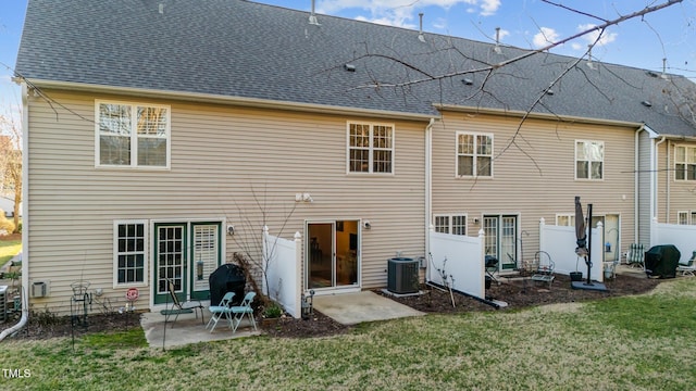 back of property featuring a yard, roof with shingles, a patio area, and central air condition unit