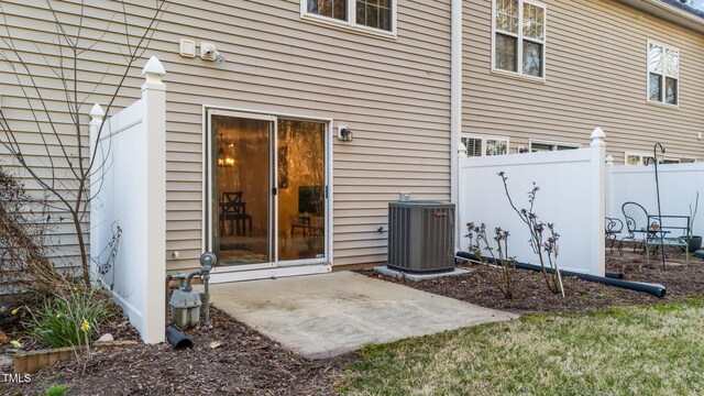 property entrance with a patio area, central AC, and fence