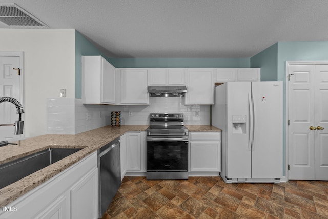 kitchen with under cabinet range hood, a sink, visible vents, white cabinets, and appliances with stainless steel finishes