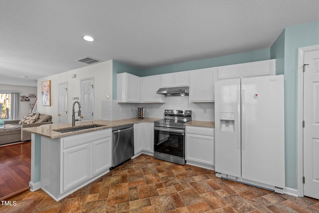 kitchen with under cabinet range hood, a peninsula, a sink, visible vents, and appliances with stainless steel finishes