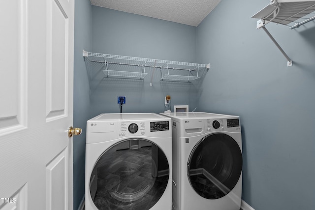 laundry area featuring a textured ceiling, laundry area, and washer and dryer