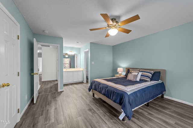 bedroom featuring a ceiling fan, a textured ceiling, baseboards, and wood finished floors