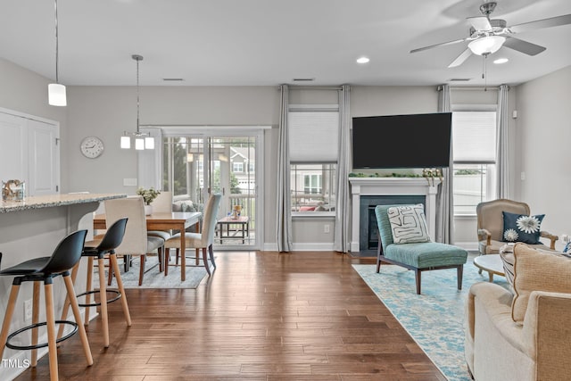 living room with a fireplace with flush hearth, a ceiling fan, dark wood-style floors, recessed lighting, and baseboards